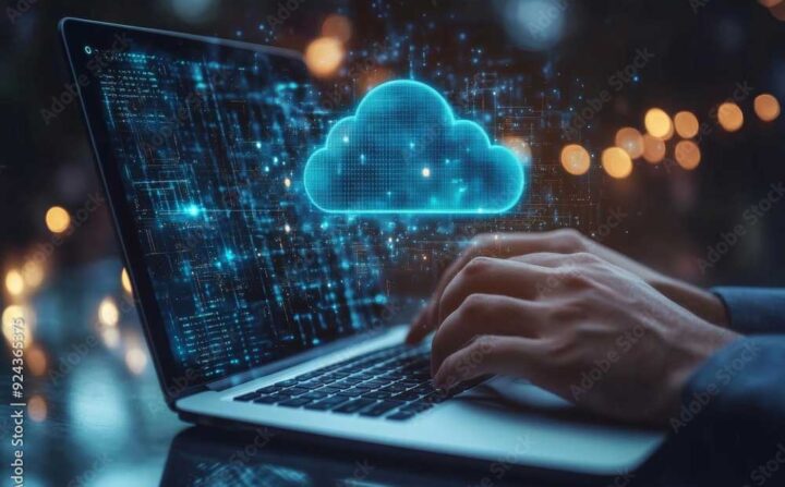 Person sitzt am Notebook, man sieht eine Hand und eine Darstellung einer Wolke