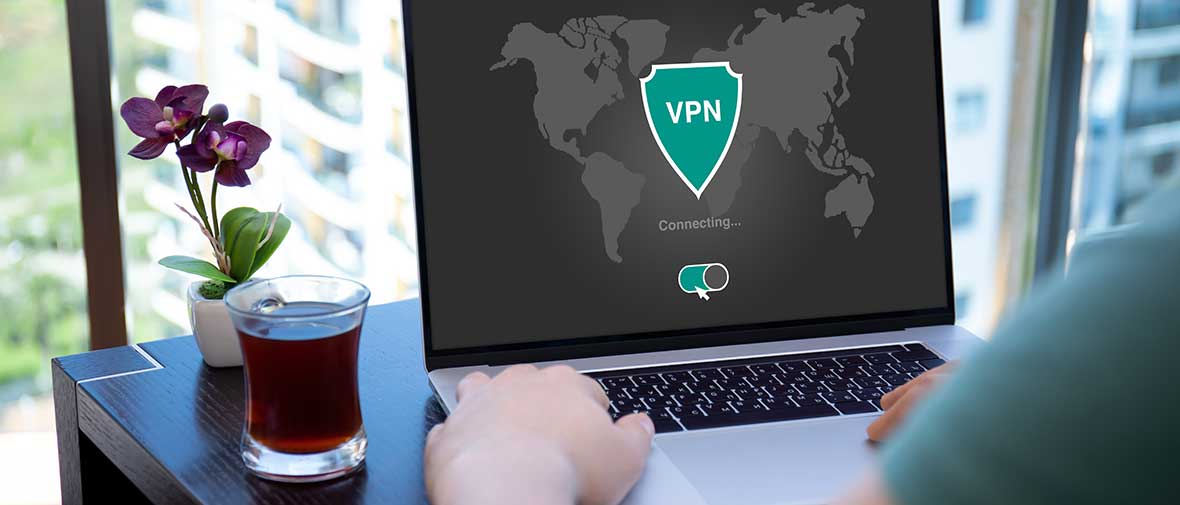 VPN: Ein Mann sitzt an einem Laptop, auf dem Bildschirm ist VPN zu lesen.